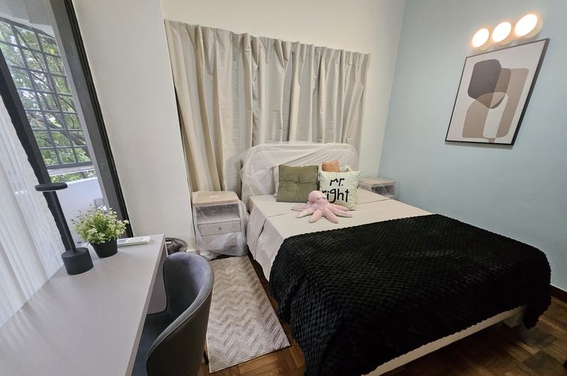 Common room with a bed, bedside tables, wall lights and a study desk and chair by the window