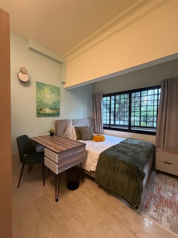 Common room with a bed, study desk and chair, bedside drawers and a large window looking onto trees
