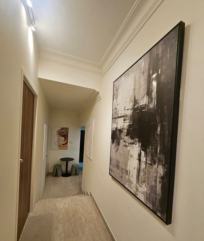 Hallway with framed artwork leading to the dining corner